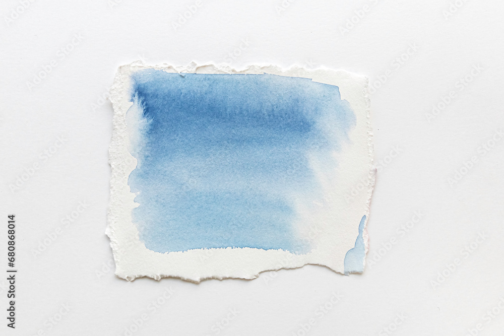 White Ripped Piece of Paper with watercolor blue streaks isolated. Top View of Blank Adhesive Paper Tag. Blank Note with Copy Space for Text or Image. White Ripped Piece of Paper with watercolor blue streaks isolated. Top View of Blank Adhesive Paper Tag. Blank Note with Copy Space for Text or Image.