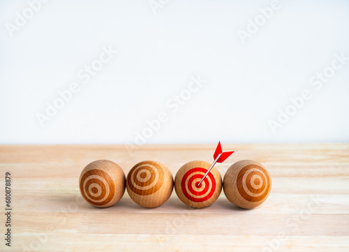 Focus on the right target, objective, business goals concepts. Red bullseye icon on wooden sphere ball with arrow on red spot, dartboard, isolated on white background with copy space, minimal style.