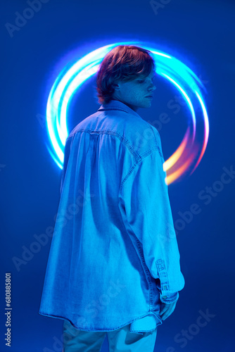 rear view portrait of young attractive man posing in neon lights and vivid colors illuminated vivid abstract, creative digital reflection.