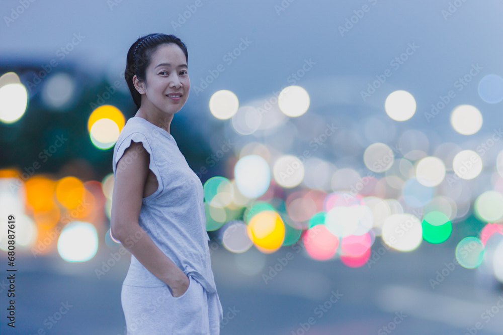 Fototapeta premium Portrait of happy smile asian woman with bokeh light in background.