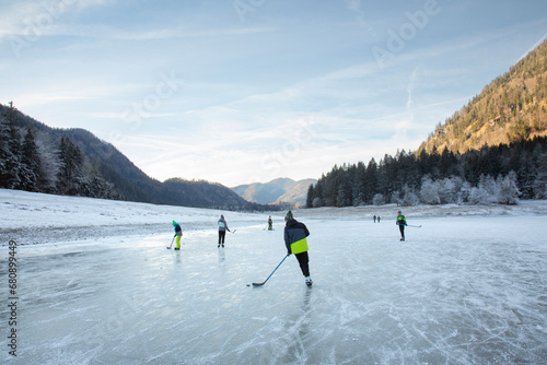 People playing ice hockey on frozen Lake Lodensee, Germany photo