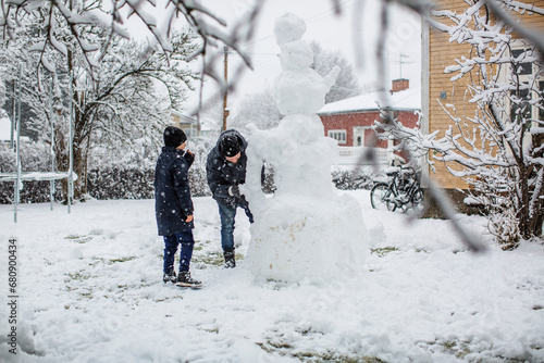 Man making snowman with his son photo