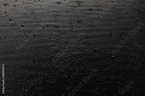 Ripples from raindrops in puddle photo