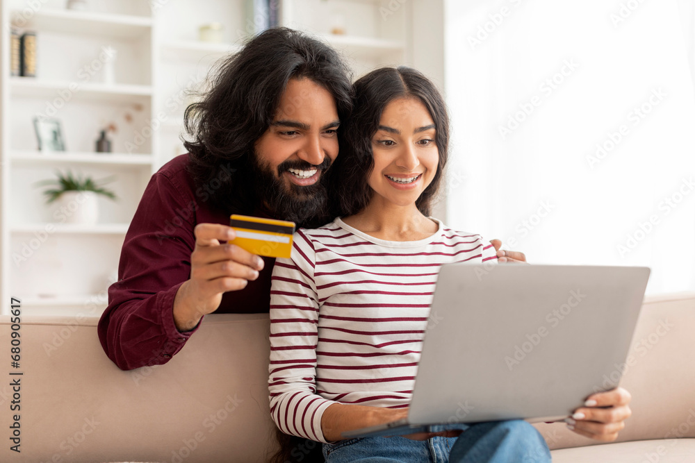 Happy young indian family shopping or banking online from home Happy young indian family shopping or banking online from home