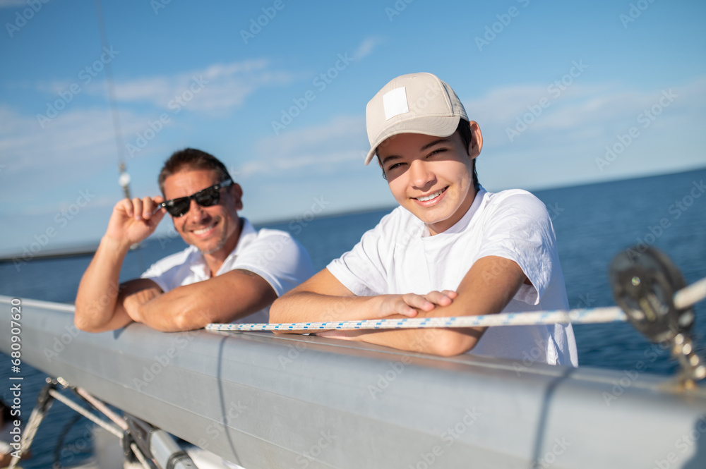 Father and son sailing and looking happy and joyful