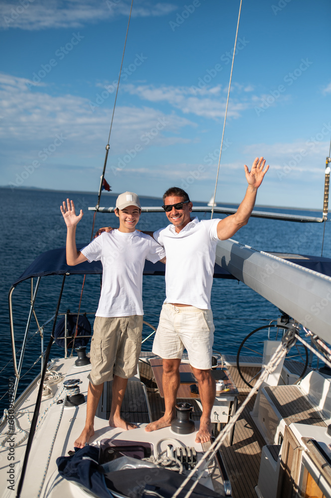 Naklejka premium Dad and son on the yacht looking happy and cheerful