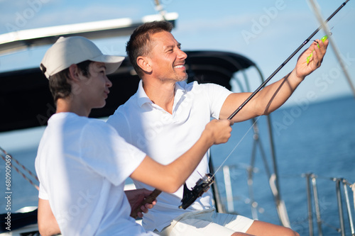 Dad and son spending time together on the yacht and fisihing