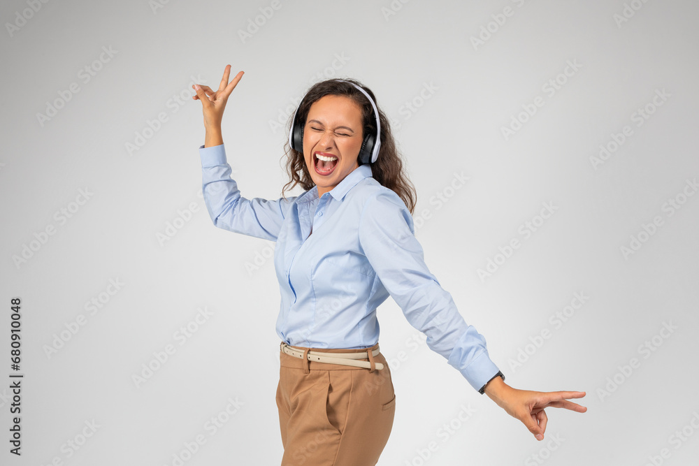 Happy caucasian young lady in wireless headphones with open mouth, listen music, sing song, dance Happy caucasian young lady in wireless headphones with open mouth, listen music, sing song, dance