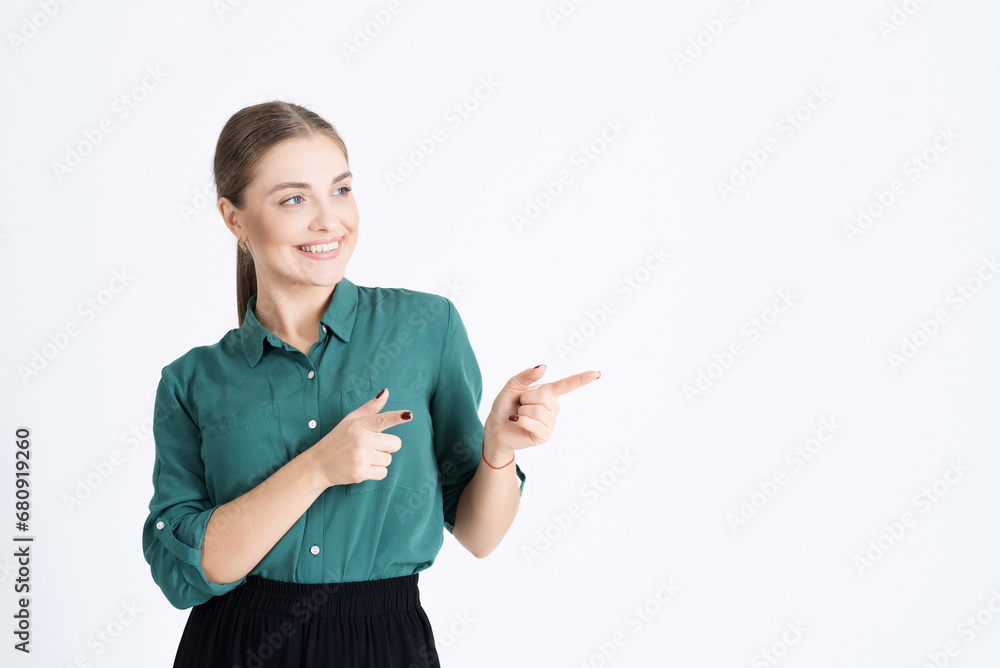 Look at this. Attractive young woman points her fingers at an empty copy space for an advertisement isolated on a white studio background Look at this. Attractive young woman points her fingers at an empty copy space for an advertisement isolated on a white studio background
