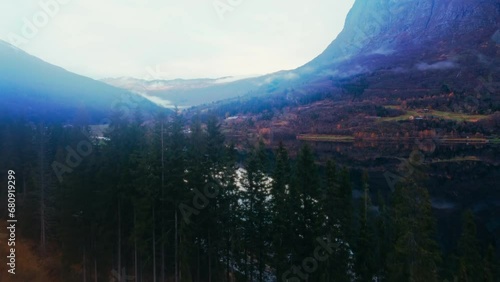 Breathtaking Aerial Footage of Mountains, Fjord, and Waterfall Wrapped in Trees and Clouds in a Stunning Wilderness Scene
