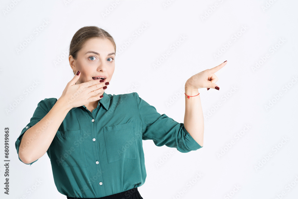 Look at this. Attractive young woman shocked by something points her finger at an empty copy space for advertising isolated on a white studio background Look at this. Attractive young woman shocked by something points her finger at an empty copy space for advertising isolated on a white studio background