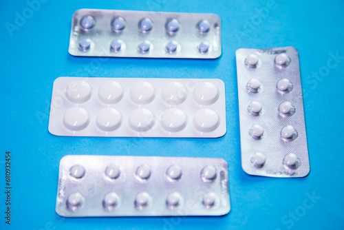 Pills in blister packs on blue background close-up