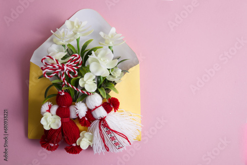 Martenitsa, Martisor with flowers in an envelope on a pink background flat lay copy space