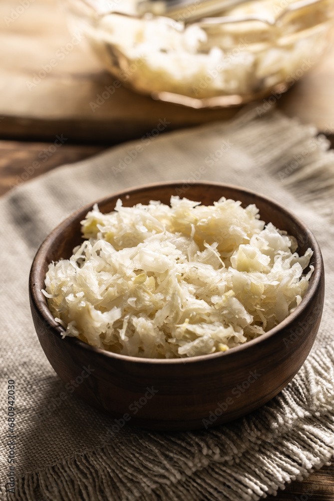 Fermented cabbage in a bowl on wooden cutting board Fermented cabbage in a bowl on wooden cutting board