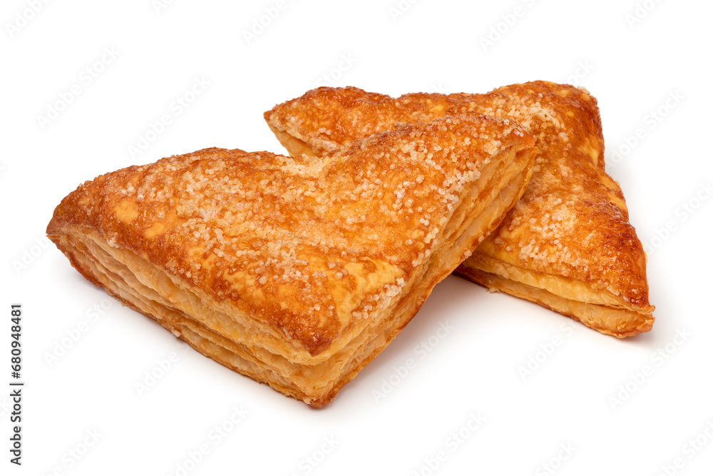 Pair of baked puff apple triangles pastry as a snack close up isolated on white background Pair of baked puff apple triangles pastry as a snack close up isolated on white background