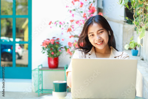happy asian woman sitting in cafe working on laptop with smile wearing casual clothes, female small business owner in outdoors