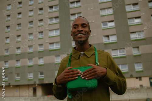 Photos Analogue style portrait of young man with autism in street wear holding green pu