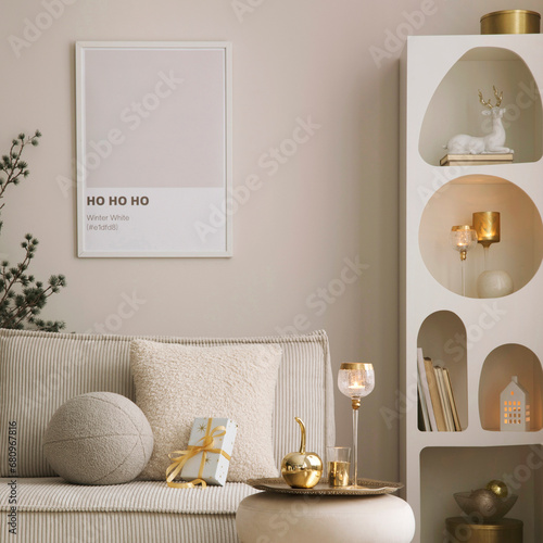 Amazing composition on white design shelf with mock up poster frame, christmas decoration, lights, gifts, lanterns ,deer, candles, stars, sofa and pouf. Santa claus is coming. Home decor. Template. photo