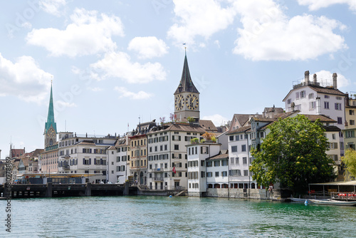 View of the historic city center with famous Saint Peter and FraumÃ¼nster Church, on the Limmat river. Zurich, Switzerland.