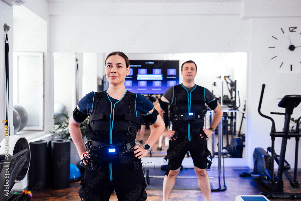 Couple of people in ems suits are preparing for workout in fitness club or gym Couple of people in ems suits are preparing for workout in fitness club or gym