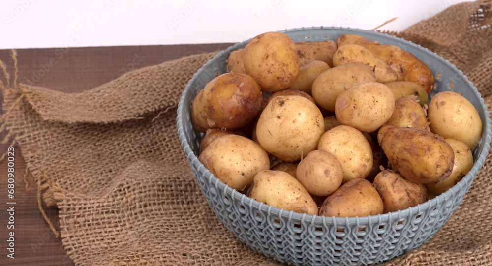 Fresh small potatoes for cooking in a wooden bowl. With copy space on white background. Fresh small potatoes for cooking in a wooden bowl. With copy space on white background.