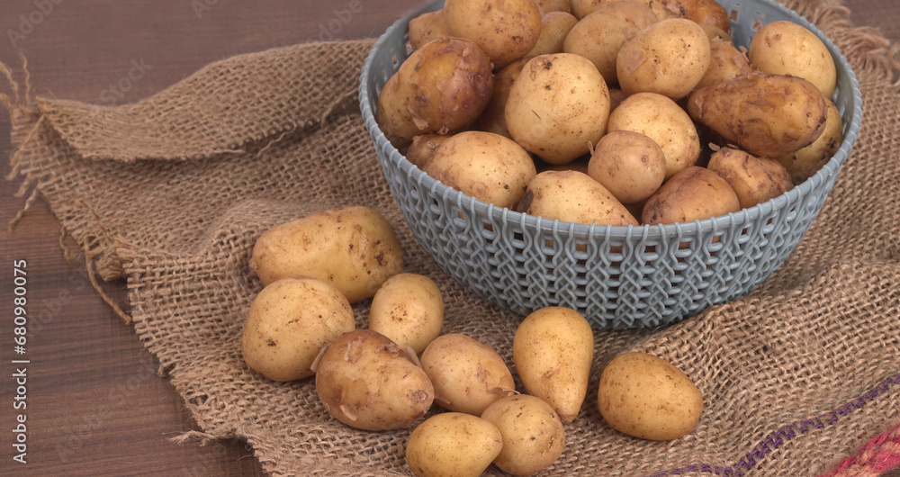 Fresh small potatoes for cooking in a wooden bowl. With copy space on white background. Fresh small potatoes for cooking in a wooden bowl. With copy space on white background.