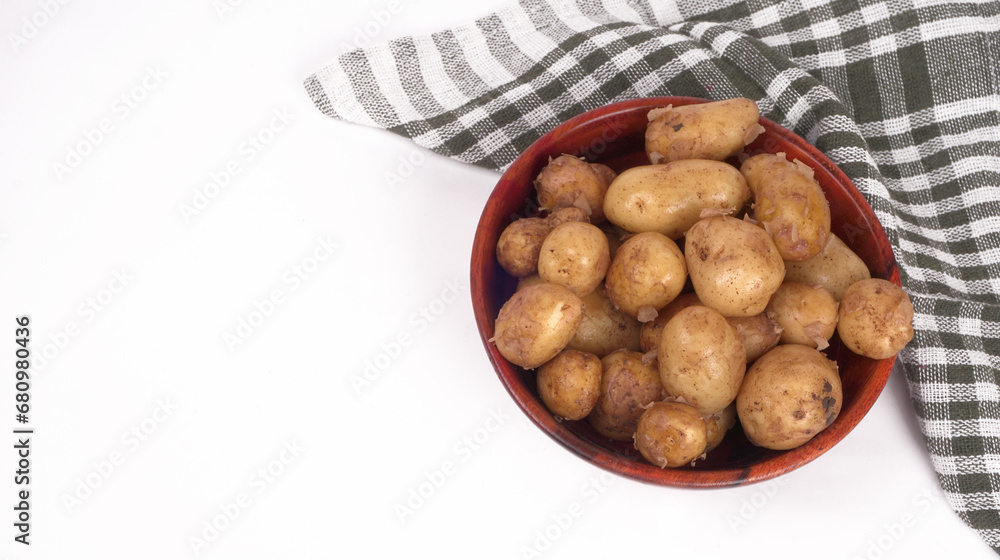 Fresh small potatoes for cooking in a wooden bowl. With copy space on white background. Fresh small potatoes for cooking in a wooden bowl. With copy space on white background.