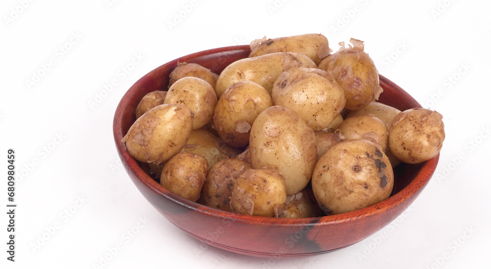 Fresh small potatoes for cooking in a wooden bowl. With copy space on white background. Fresh small potatoes for cooking in a wooden bowl. With copy space on white background.