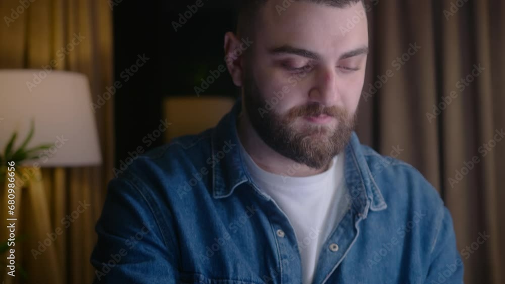 Close up shot of young bearded business man using laptop at night working from home office to meet deadline. Overworked businessman working in room in evening. Camera moving down Close up shot of young bearded business man using laptop at night working from home office to meet deadline. Overworked businessman working in room in evening. Camera moving down