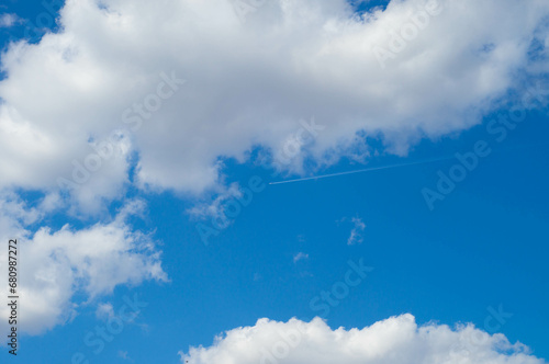 Blue sky with white clouds and airplane