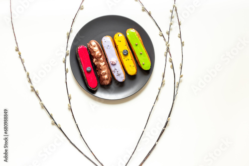 Plate of various glased eclairs cakes. Sweet food background photo