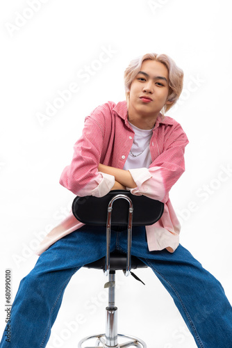guy sitting on stool. Red Long sleeve shirt. blank template t shirt. asian man posing in studio with white t shirt. Fashion clothing and cosmetics. Young model blond hair isolated on white background