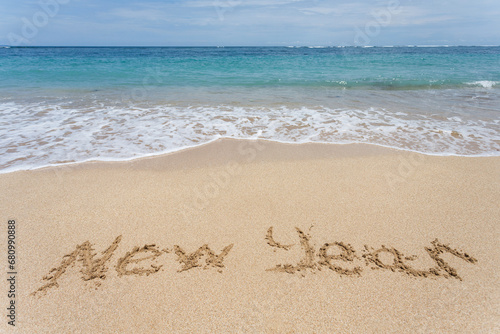 New Year written on the sand on the beach