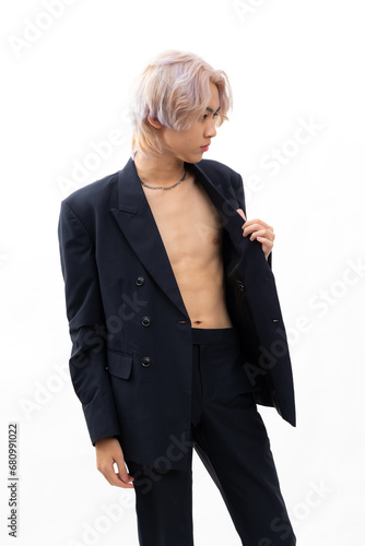 Sexy black suit and naked torso.  Fashion portrait Asian young man. model, clothing and cosmetics. Young male model blond hair in fashionable clothing isolated on white background
