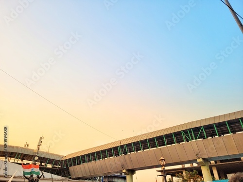 From below of skywalk outside railroad station under orange sky at sunset in Mumbai photo