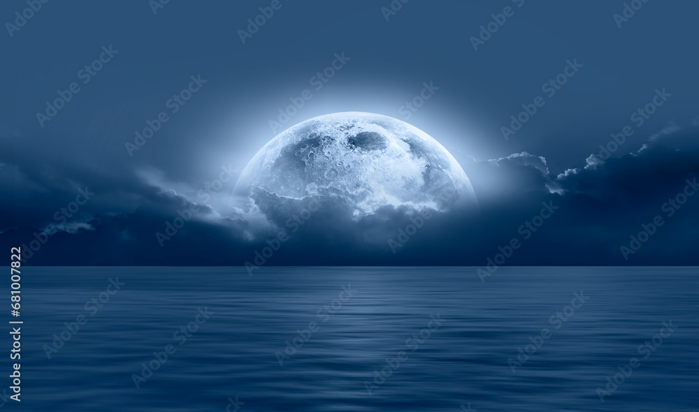 Night sky with blue moon in the clouds over the calm blue sea, many sytars in the background  