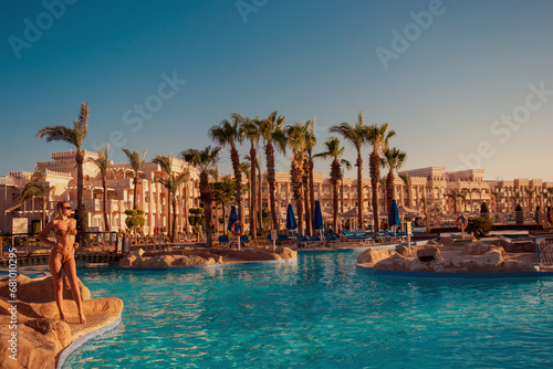 A girl in a swimsuit poses near the pool overlooking the hotel complex in Hurghada