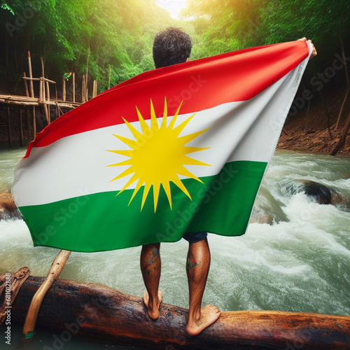 A young man raises the Kurdistan flag in a pleasant atmosphere photo