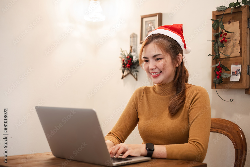 A startup employee writes a report on a laptop on Christmas Eve. In an office decorated with colorful bulbs and lights during the Christmas holidays A startup employee writes a report on a laptop on Christmas Eve. In an office decorated with colorful bulbs and lights during the Christmas holidays