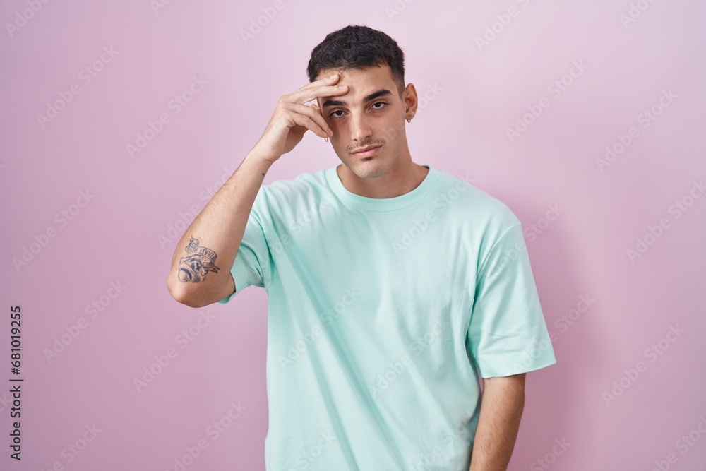 Handsome hispanic man standing over pink background worried and stressed about a problem with hand on forehead, nervous and anxious for crisis Handsome hispanic man standing over pink background worried and stressed about a problem with hand on forehead, nervous and anxious for crisis