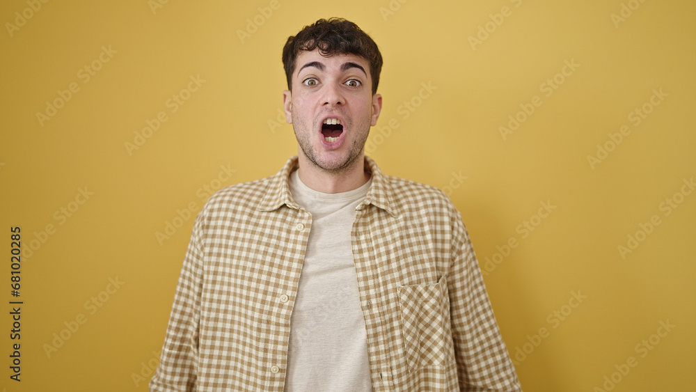 Obraz premium Young hispanic man standing with surprise expression over isolated yellow background