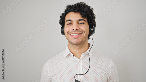 Young latin man business worker smiling confident wearing headphones over isolated white background