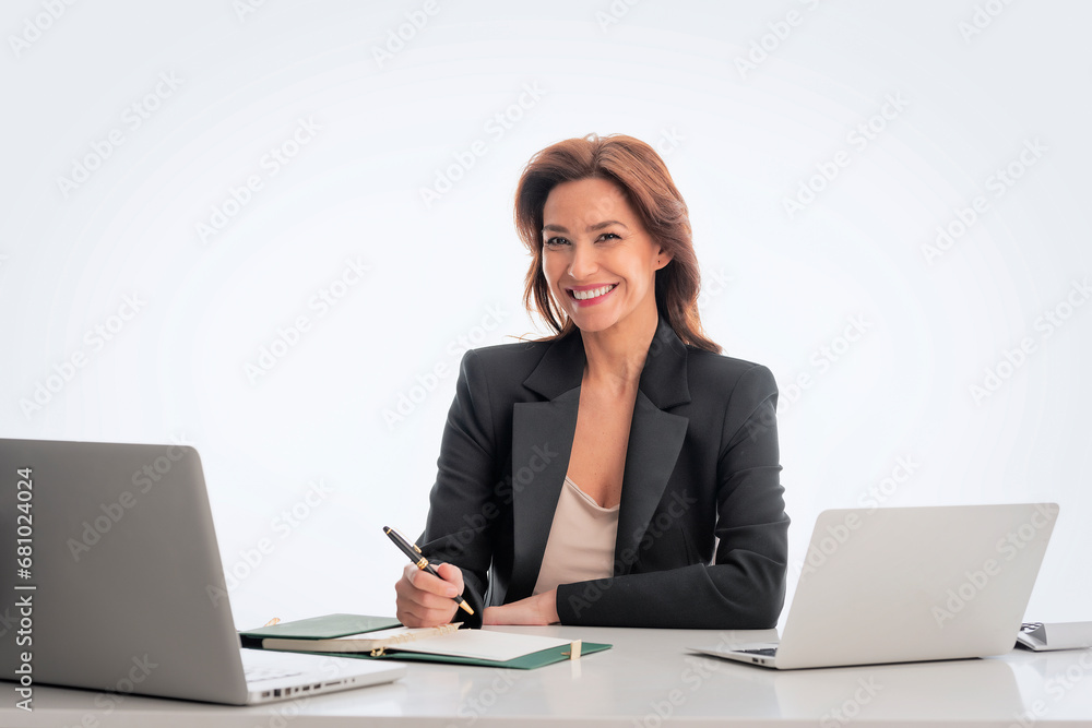 Studio shot of an attractive mid aged businesswoman using laptop against isolated background Studio shot of an attractive mid aged businesswoman using laptop against isolated background