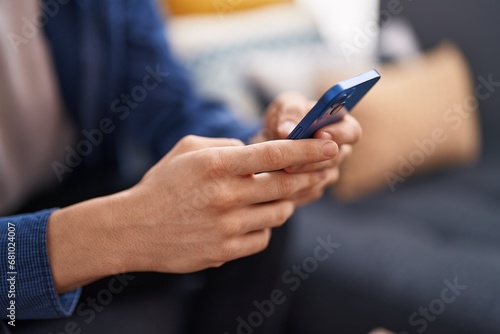 Young caucasian man using smartphone at home