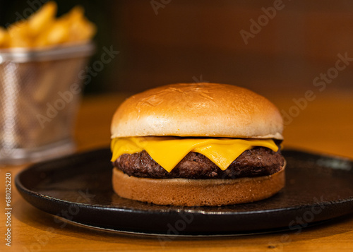 Cheeseburguer com simples com batata frita em segundo plano photo