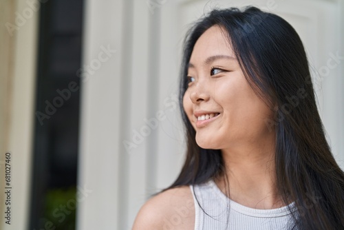 Young chinese woman smiling confident looking to the side at street