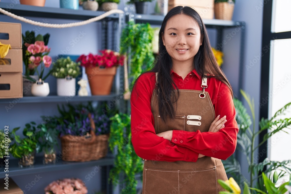 Young chinese woman florist smiling confident standing with arms crossed gesture at flower shop