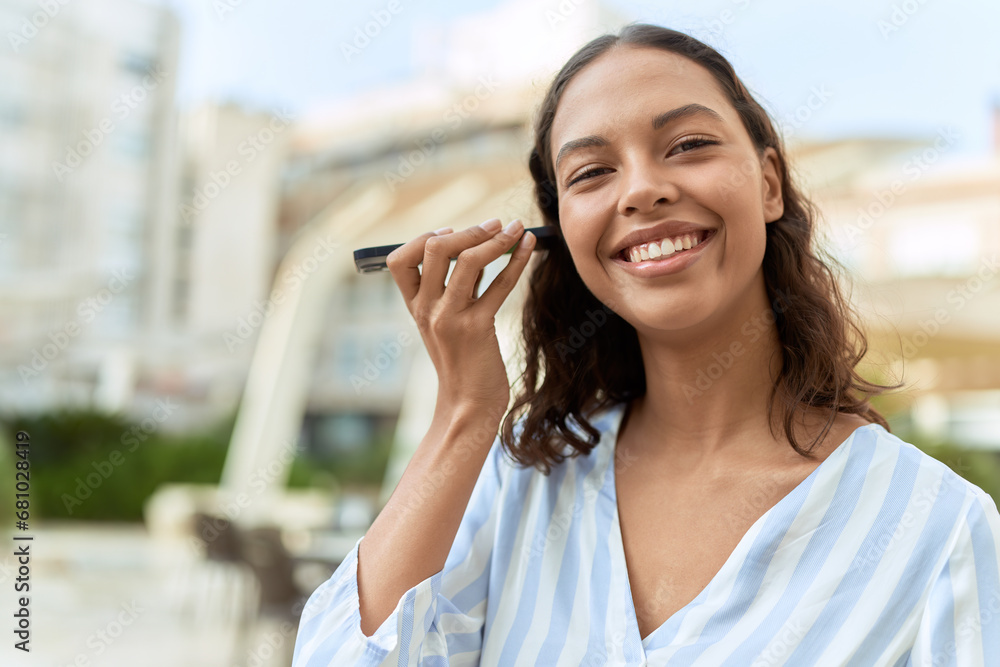 Young african american woman smiling confident listening audio message by the smartphone at coffee shop terrace