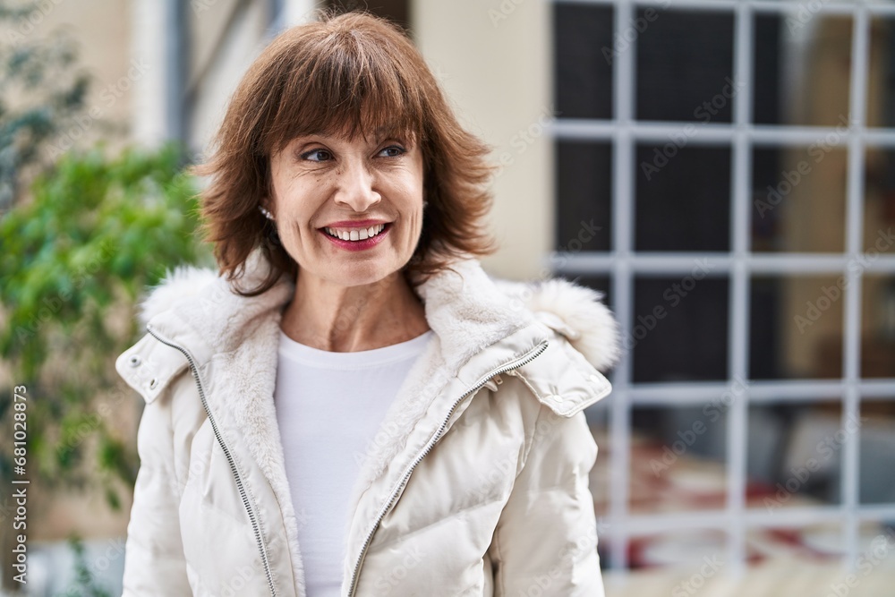 Middle age woman smiling confident looking to the side at coffee shop terrace Middle age woman smiling confident looking to the side at coffee shop terrace