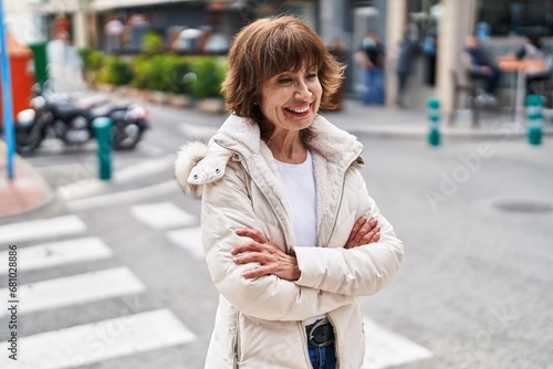 Middle age woman standing with arms crossed gesture at street © Krakenimages.com